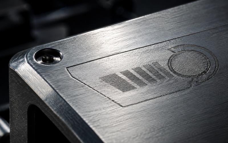 Macro detail of a brushed aluminium machine panel showing texture and machining marks